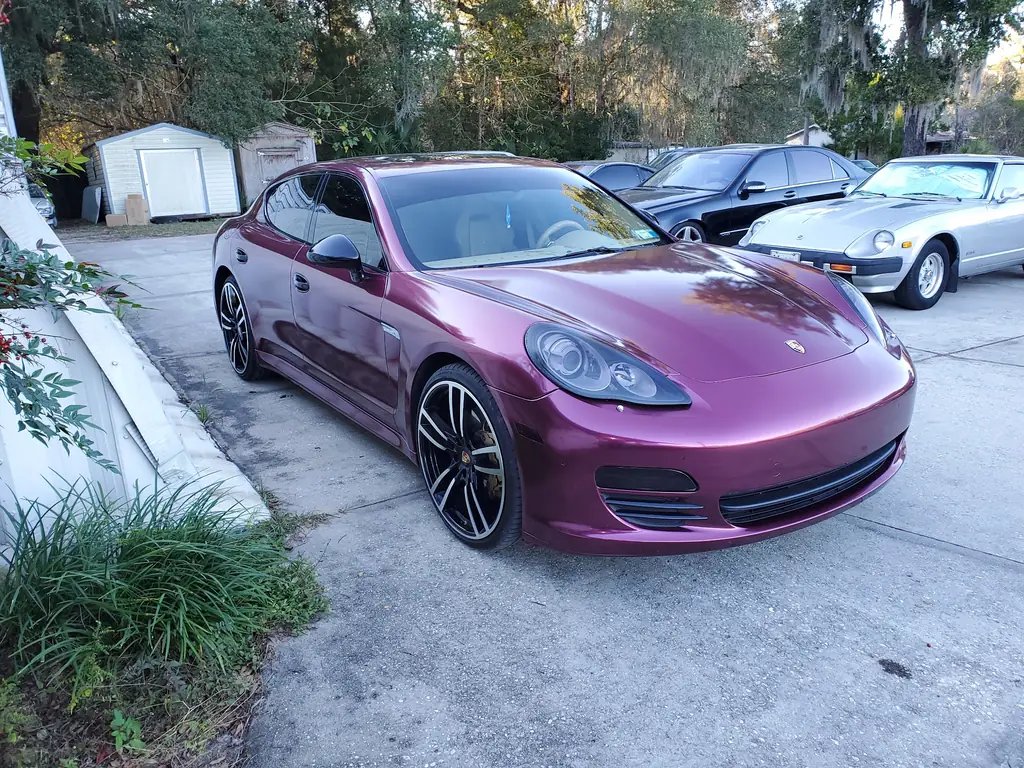 Purple Porsche Panamera on the Z Cars of Ocala lot with a Datsun 280ZX parked behind it
