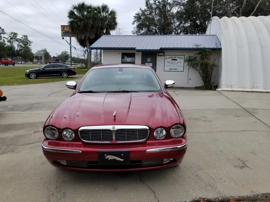 Red Jaguar XJ parked in front of the Z Cars of Ocala shop sign at 3700 N US Hwy 441